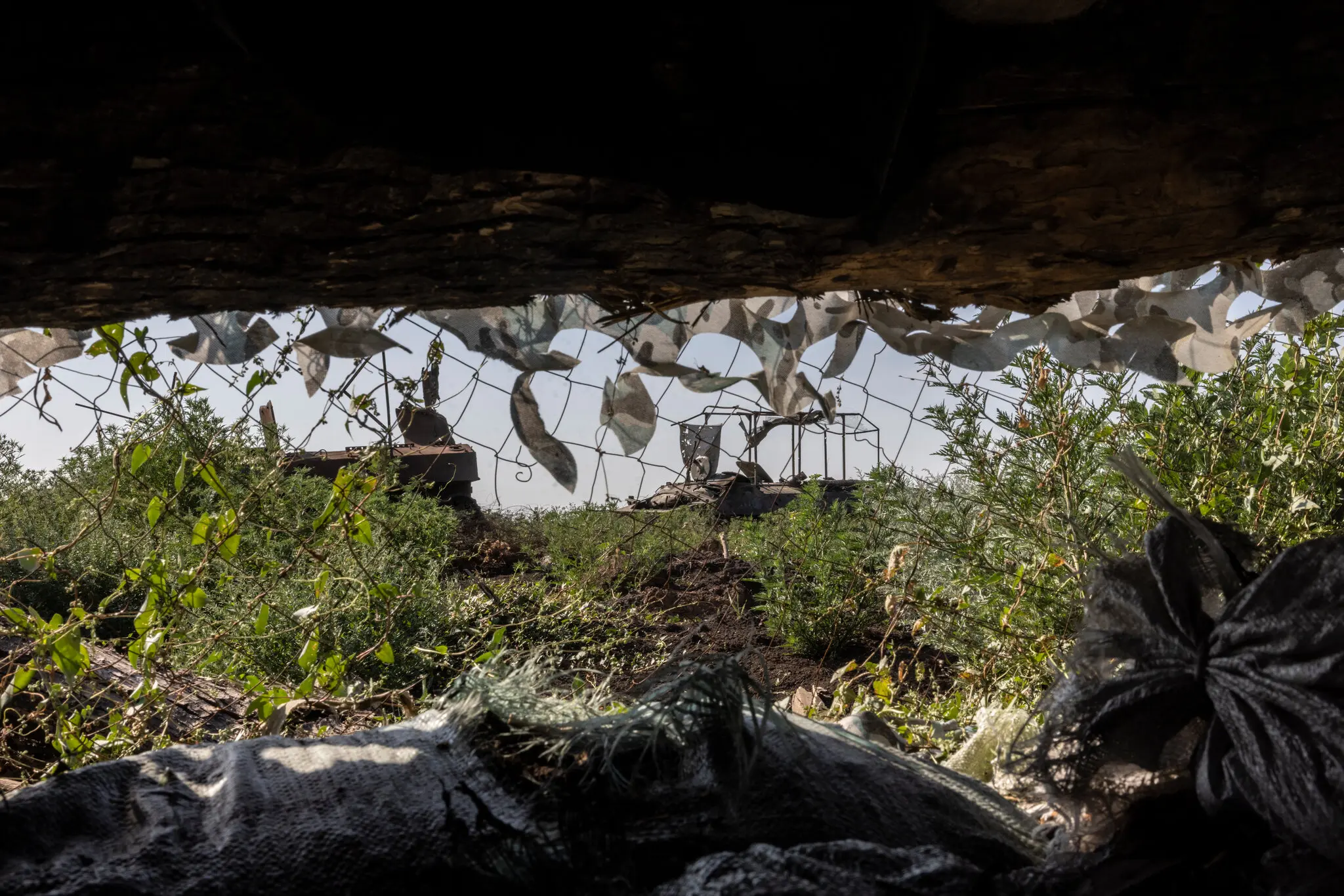 Російська бронетехніка, знищена під час попереднього російського штурму, у відкритому полі поблизу українських солдатів, дислокованих усередині глиняного рову.